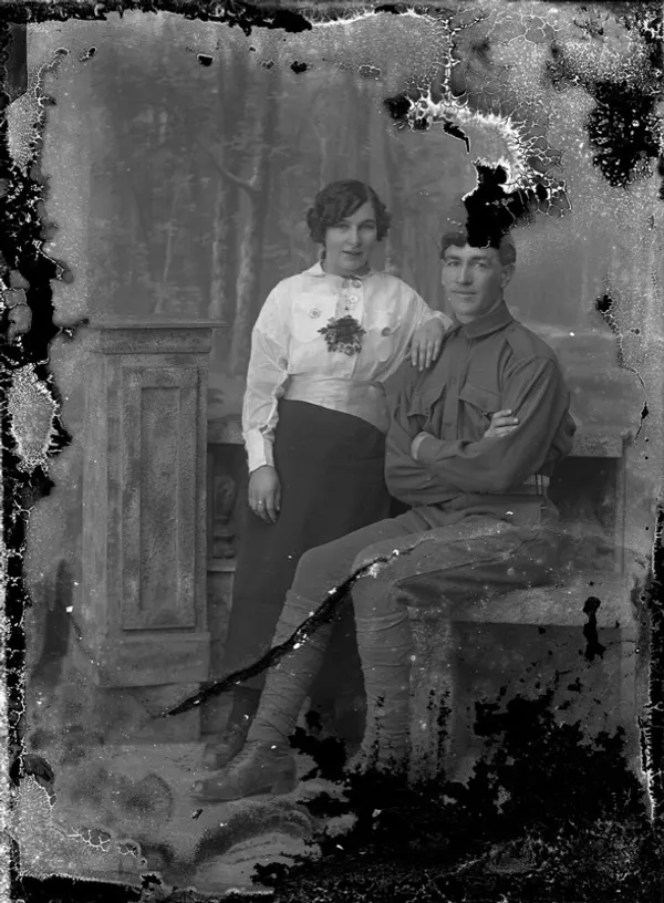 Damaged old photo of a soldier and a young woman, before photo restoration